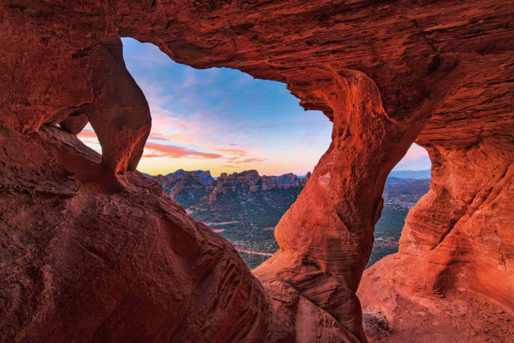 Sedona red rock arch framing mountains at sunset hiking view